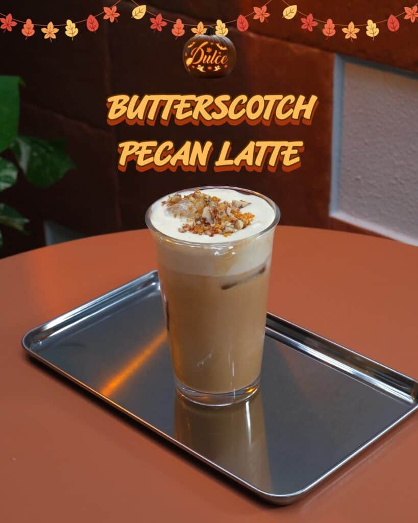 Butterscotch Pecan Latte with a cream cap, chopped pecans and butterscotch crunch on a steel tray at Dulce de Saigon